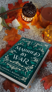 The cover of Married by War, surrounded by fall leaves and lights